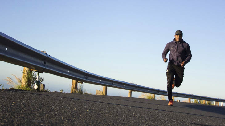 Мужчина в спортивной форме бежит по асфальтированной дороге (для чего нужен спорт)