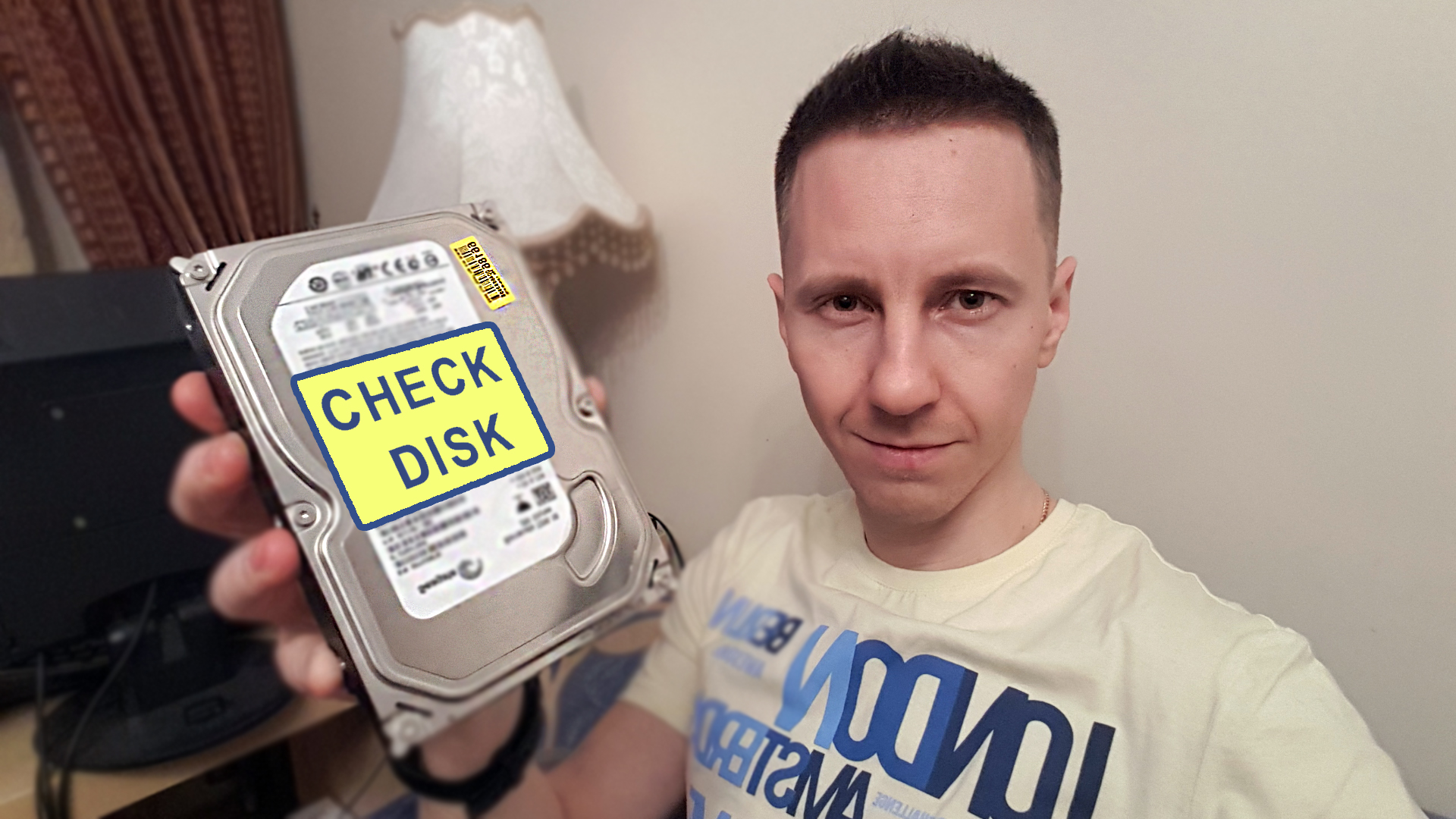 Автор Владимир Белев держит жесткий диск в руках с надписью CHECK DISK на нем.